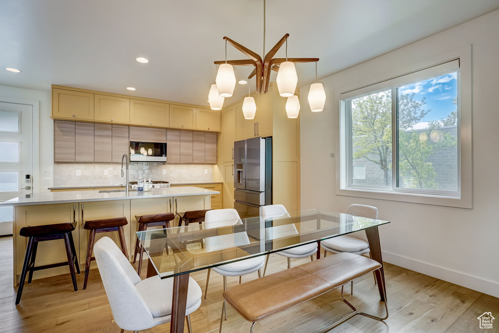 Dining area with light hardwood / wood-style flooring and sink