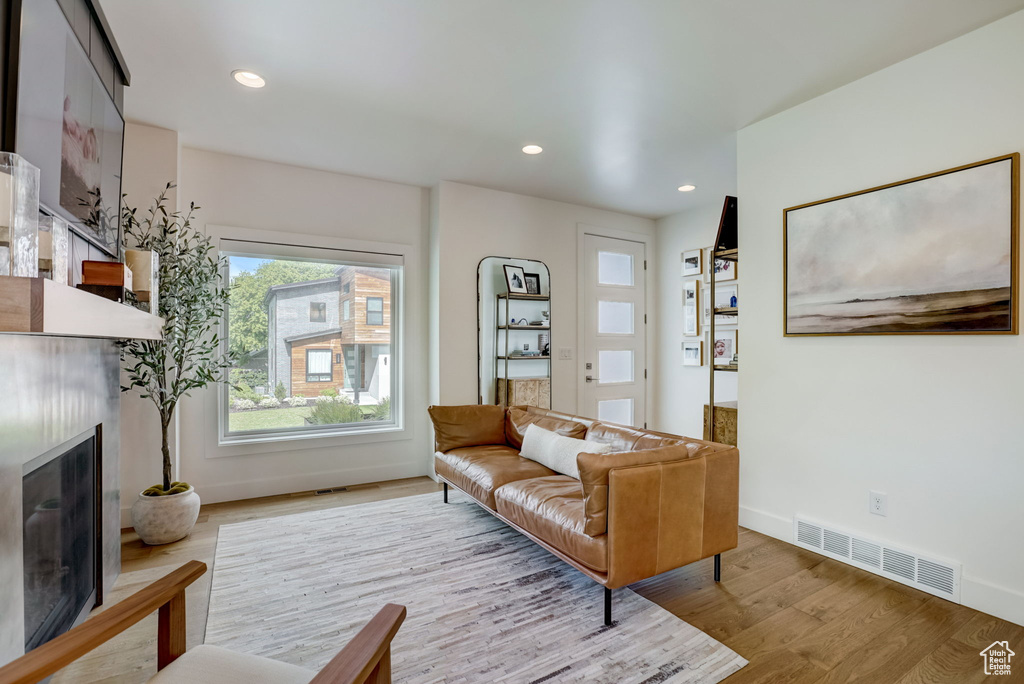 Living room with light wood-type flooring and a premium fireplace