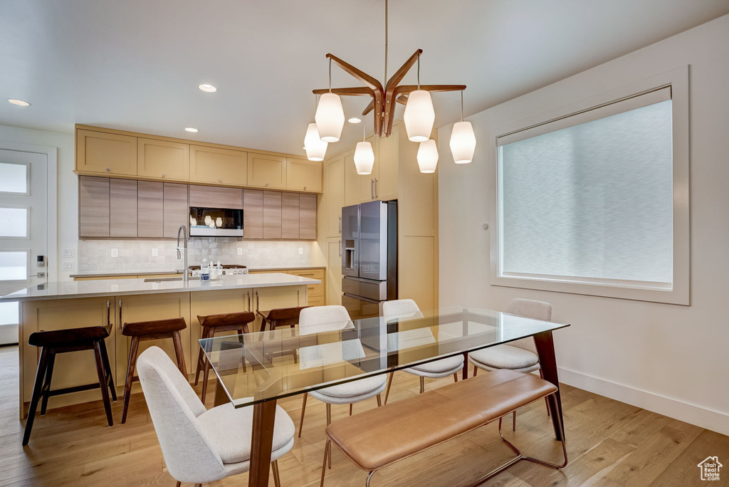 Dining area with sink and light wood-type flooring