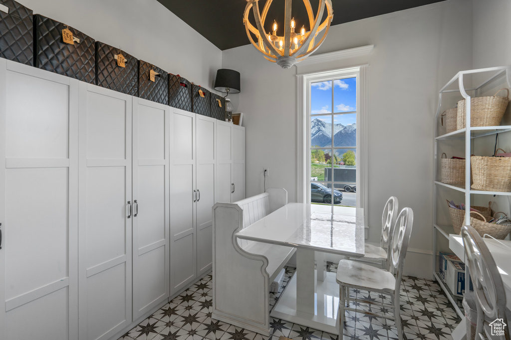 Tiled dining room with a chandelier