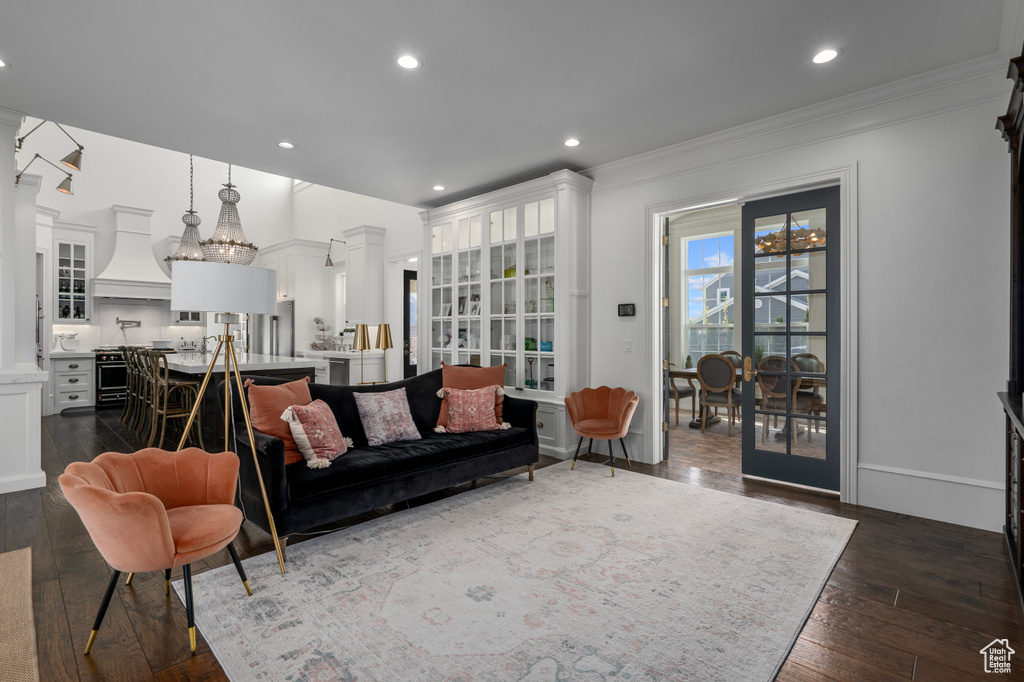 Living room featuring ornate columns, dark hardwood / wood-style flooring, and ornamental molding