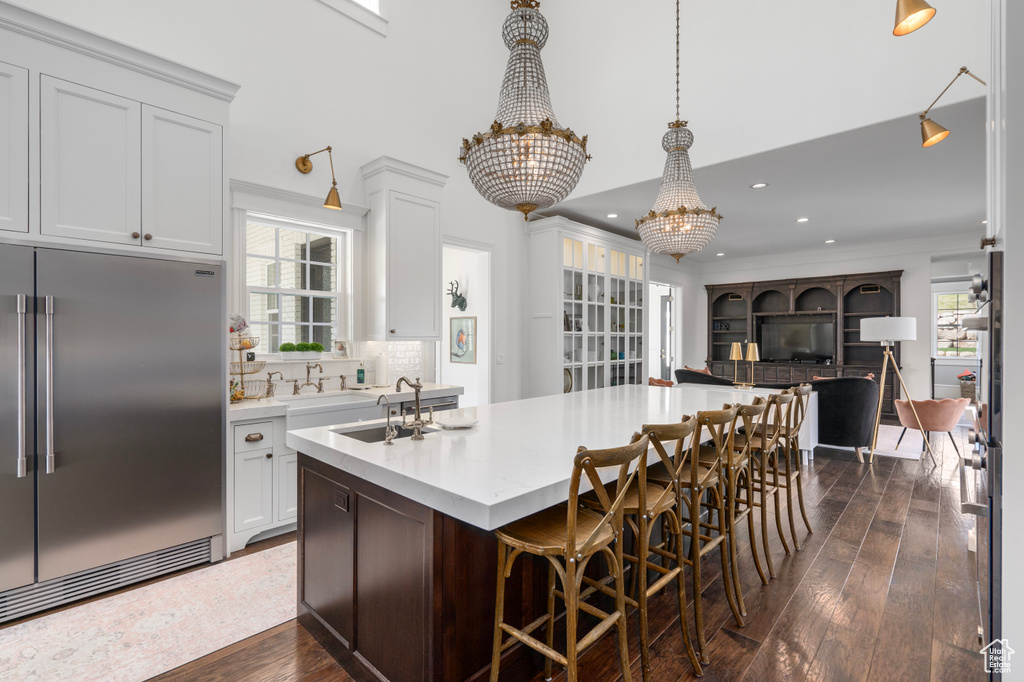 Kitchen featuring built in refrigerator, dark wood-type flooring, and plenty of natural light