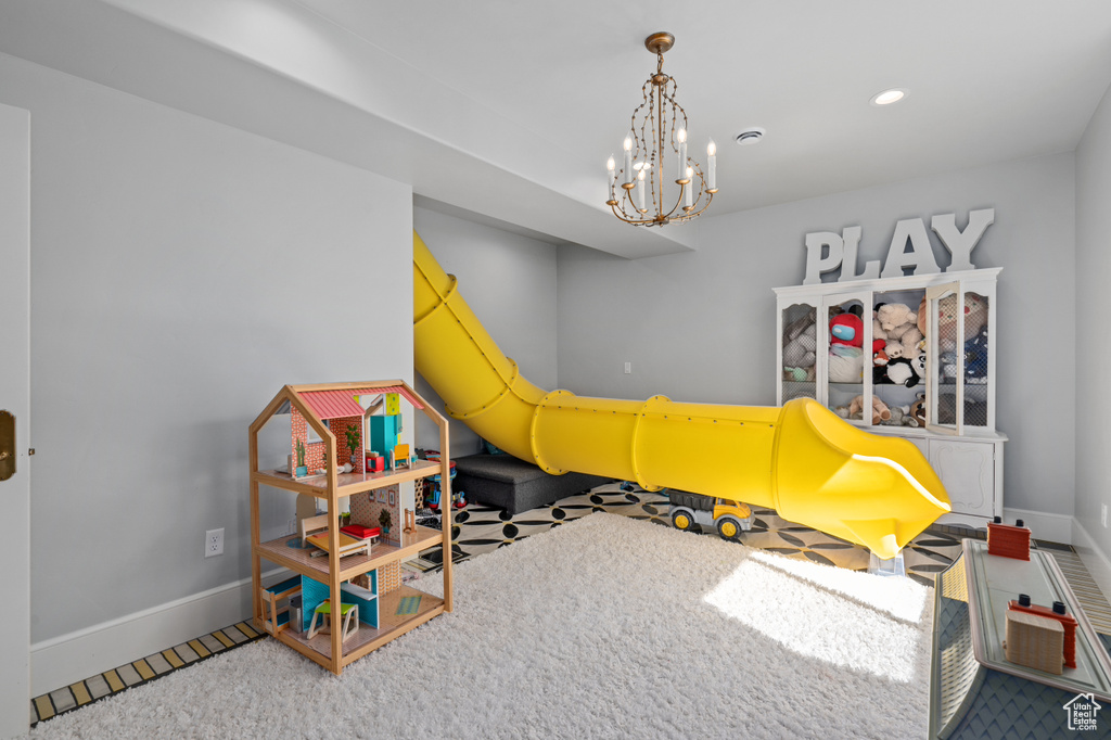 Game room with a notable chandelier and carpet floors