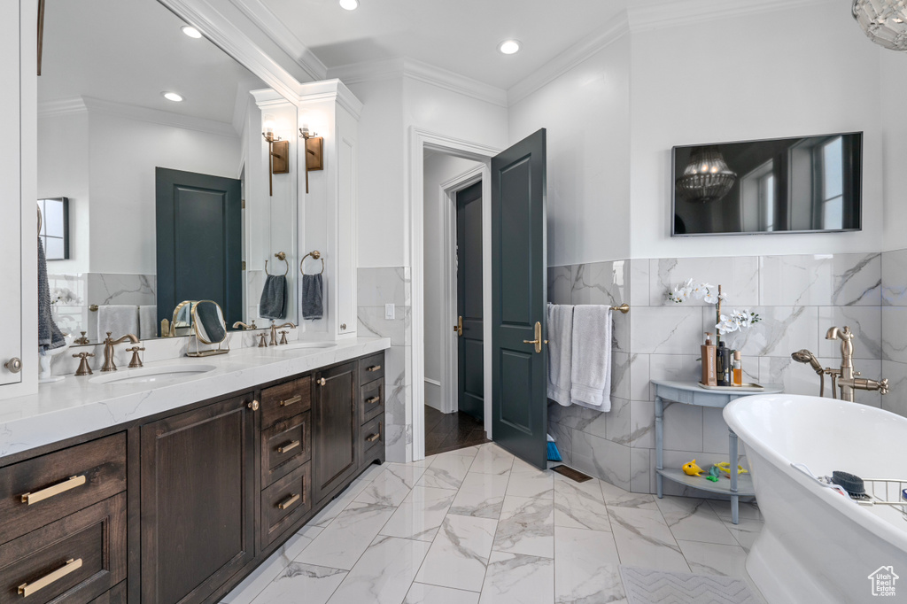 Bathroom with ornamental molding, tile floors, tile walls, and large vanity