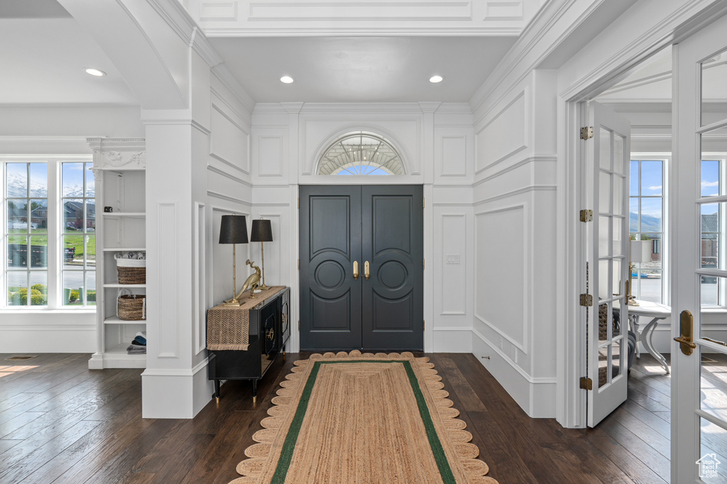 Entrance foyer featuring french doors, ornate columns, and dark wood-type flooring