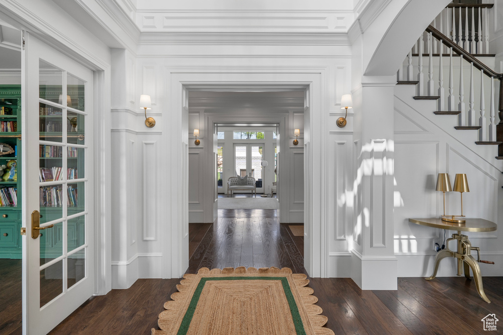 Foyer featuring dark hardwood / wood-style floors, french doors, and crown molding