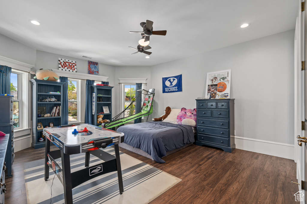 Bedroom featuring wood-type flooring, ceiling fan, and multiple windows