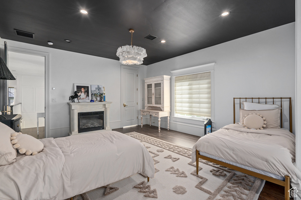 Bedroom with wood-type flooring and a notable chandelier