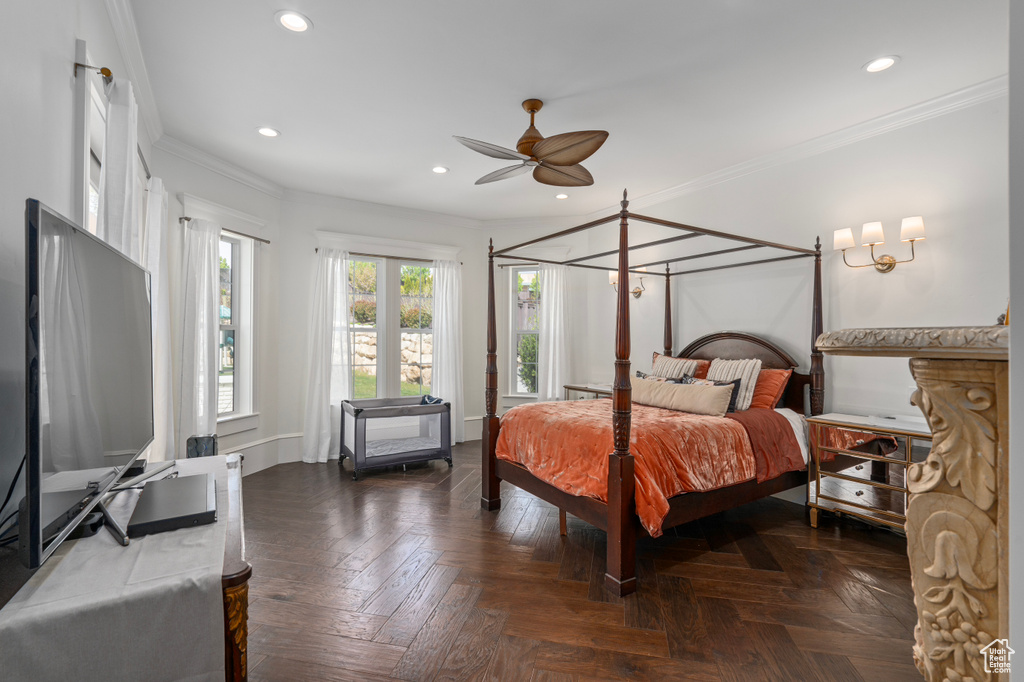 Bedroom featuring ceiling fan with notable chandelier, dark parquet floors, and crown molding