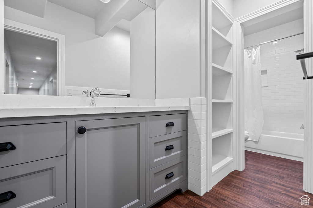 Full bathroom featuring vanity, hardwood / wood-style flooring, toilet, and shower / bath combo with shower curtain