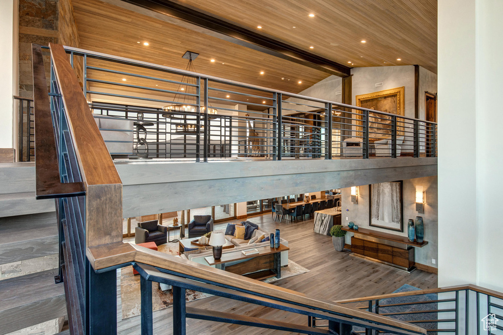 Stairway featuring high vaulted ceiling, hardwood / wood-style flooring, and wood ceiling