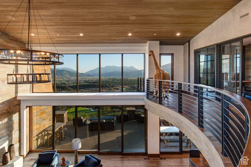 Interior space featuring a chandelier, hardwood / wood-style flooring, wood ceiling, and a mountain view