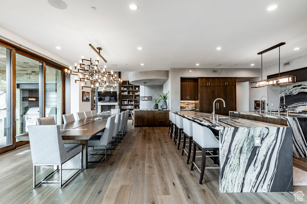 Dining area featuring an inviting chandelier, sink, and light hardwood / wood-style flooring