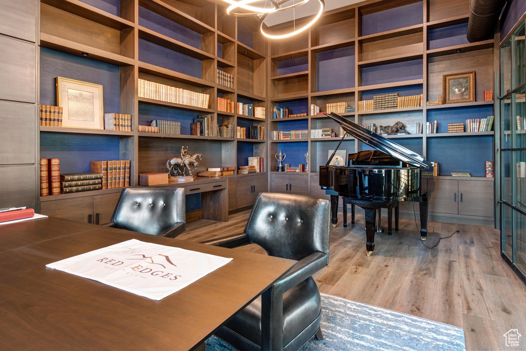 Office with built in shelves and wood-type flooring