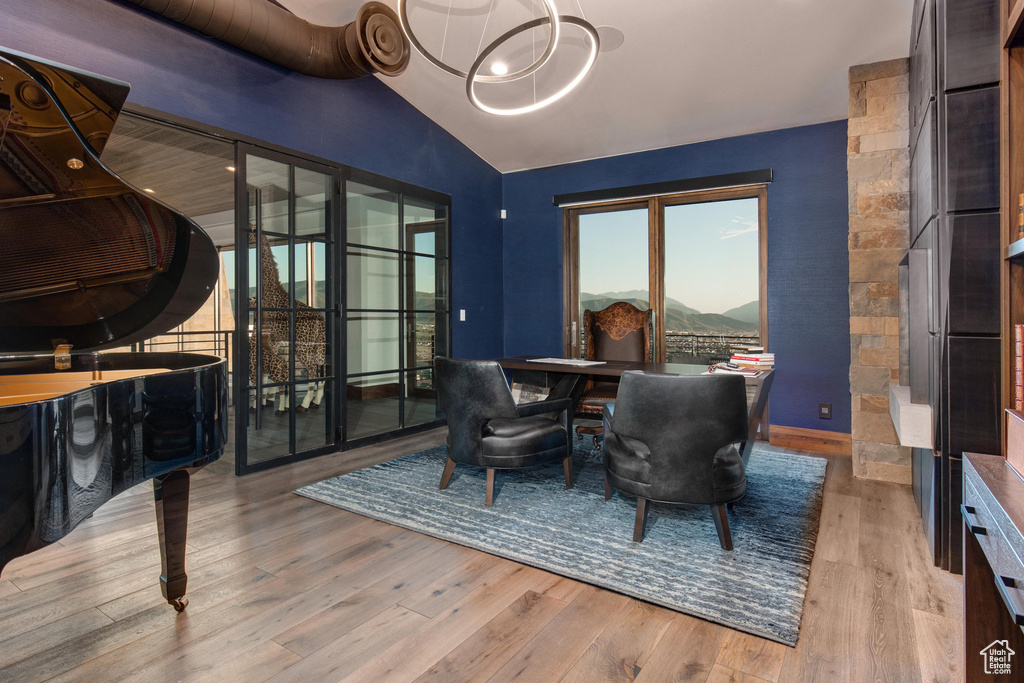 Dining space featuring a mountain view, light wood-type flooring, and vaulted ceiling