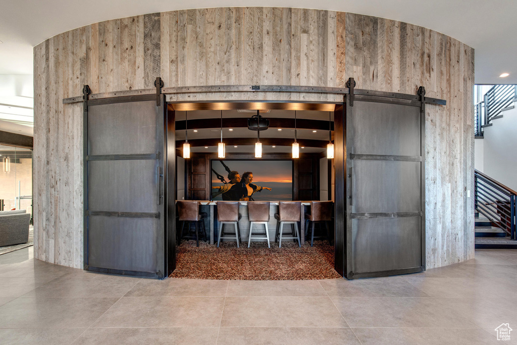 Kitchen with hanging light fixtures, a barn door, and tile flooring