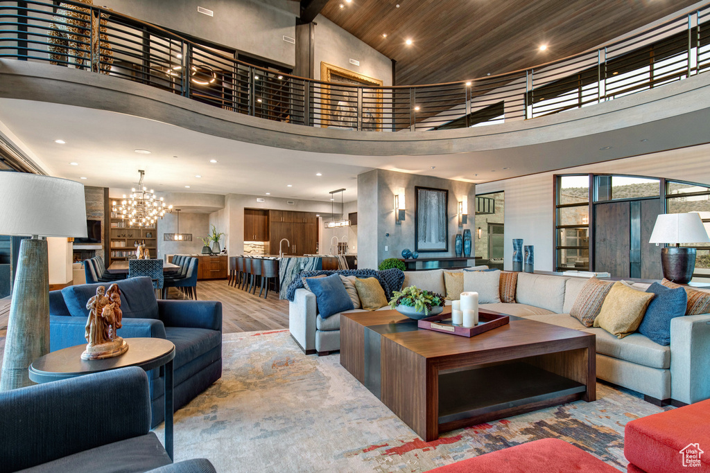 Living room with a towering ceiling, hardwood / wood-style flooring, wooden ceiling, and an inviting chandelier