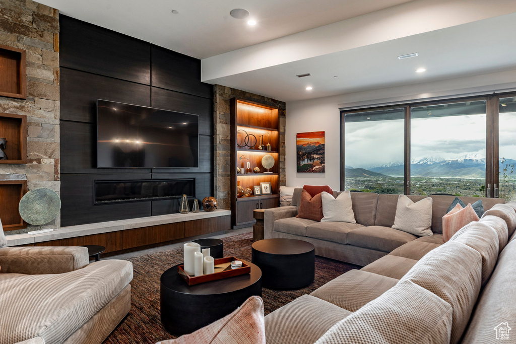 Carpeted living room featuring built in shelves, a mountain view, and a fireplace