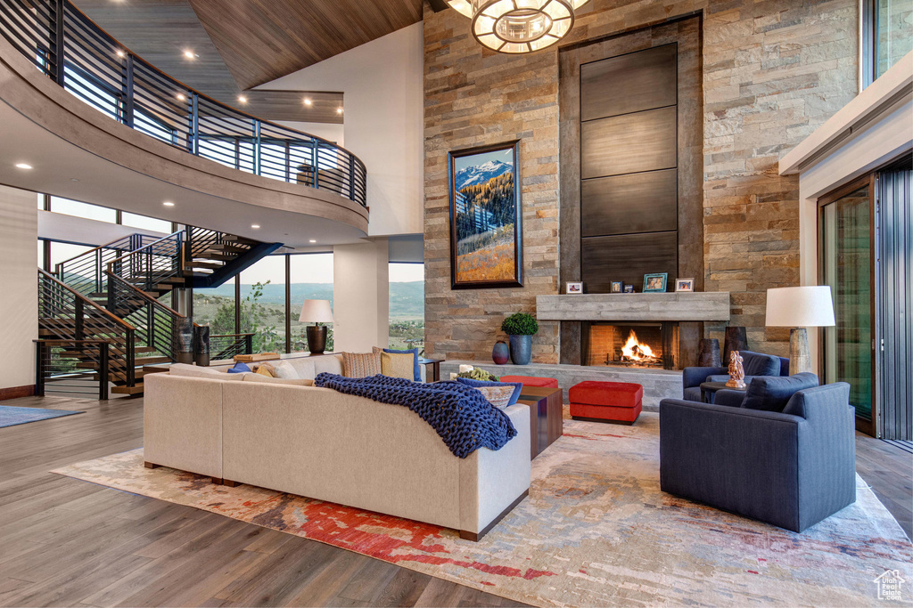 Living room featuring a fireplace, high vaulted ceiling, hardwood / wood-style floors, and wooden ceiling