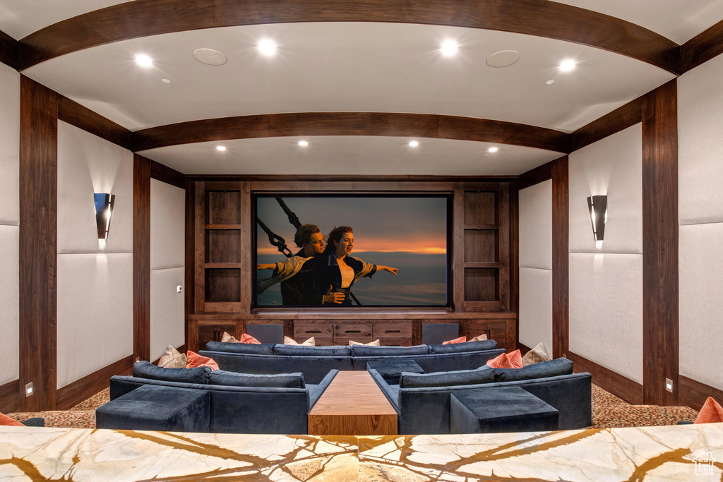 Carpeted cinema room featuring beamed ceiling and built in features