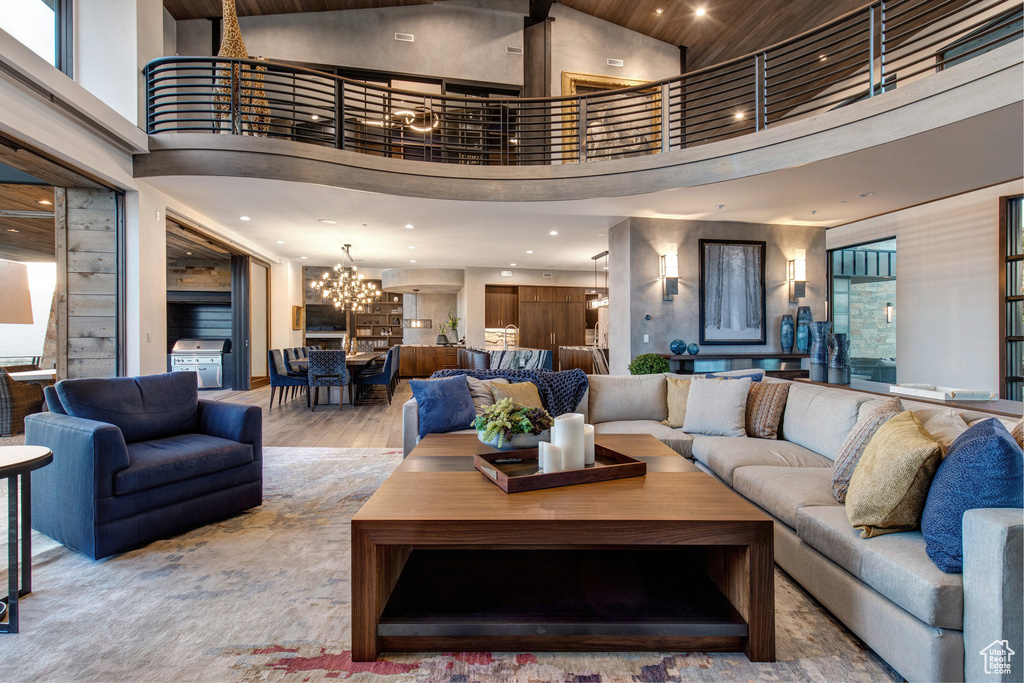 Living room with hardwood / wood-style floors, a high ceiling, and a chandelier