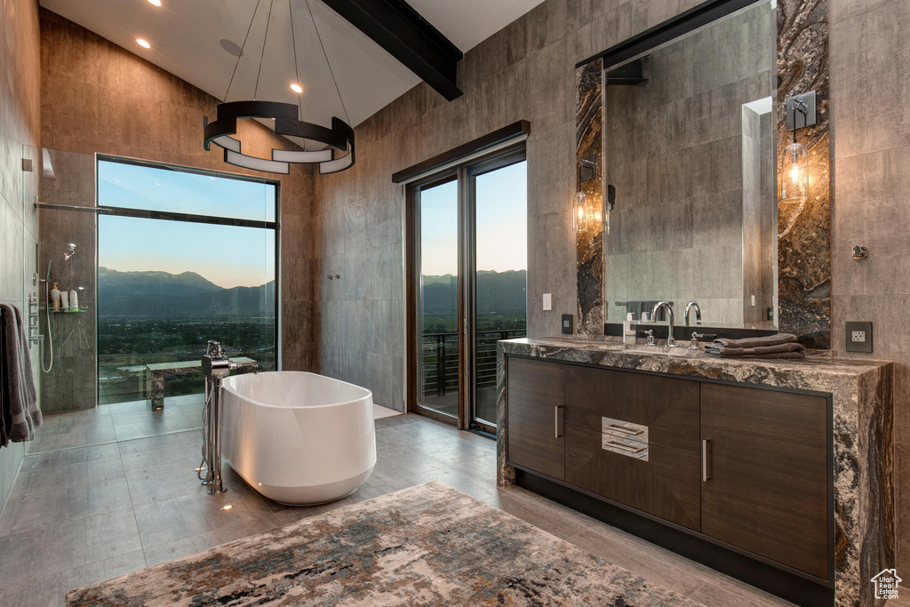 Bathroom featuring tile floors, vanity, and tile walls