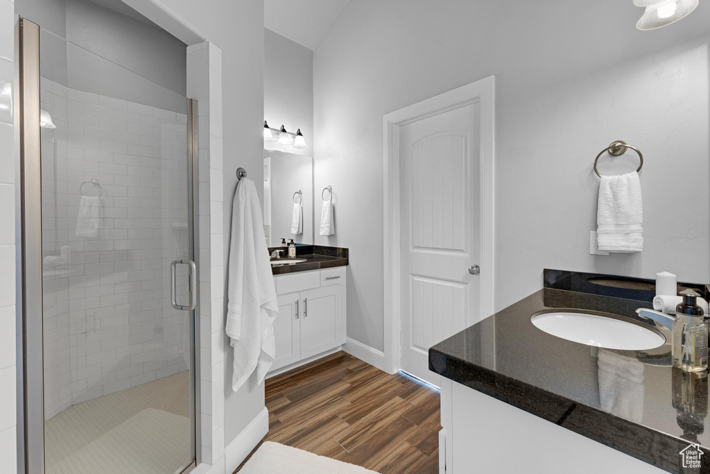 Bathroom featuring walk in shower, hardwood / wood-style floors, and dual bowl vanity