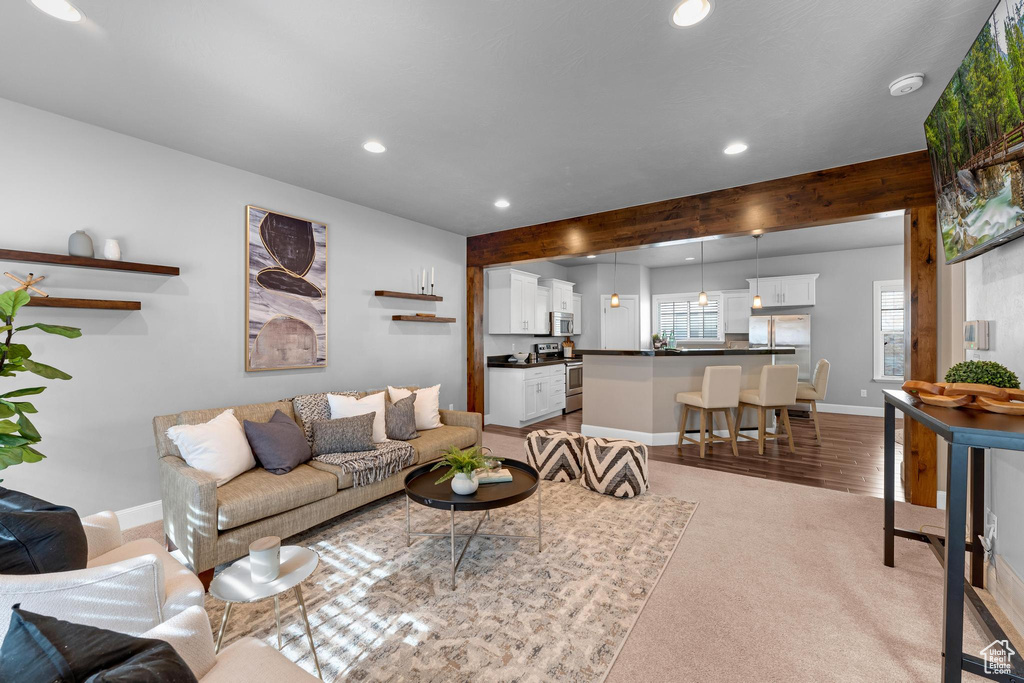 Living room with light colored carpet and beamed ceiling