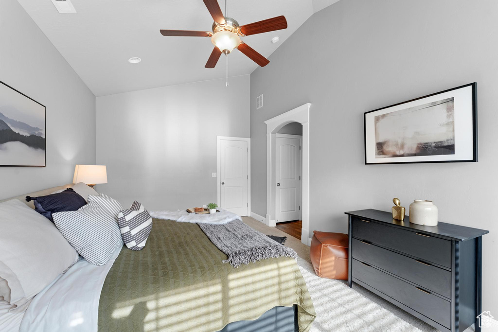 Bedroom with high vaulted ceiling, ceiling fan, and hardwood / wood-style flooring