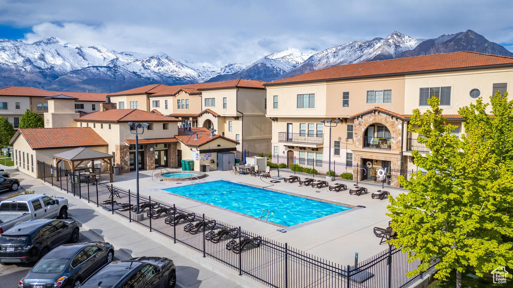 View of swimming pool with a hot tub, a patio, and a mountain view