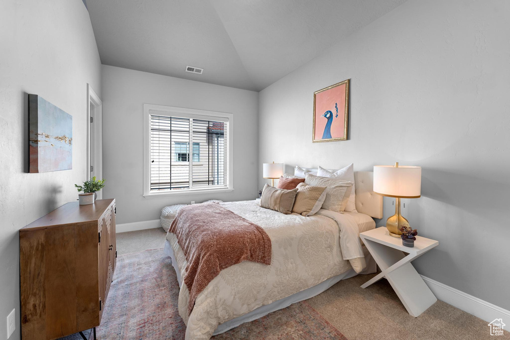 Bedroom featuring lofted ceiling and carpet