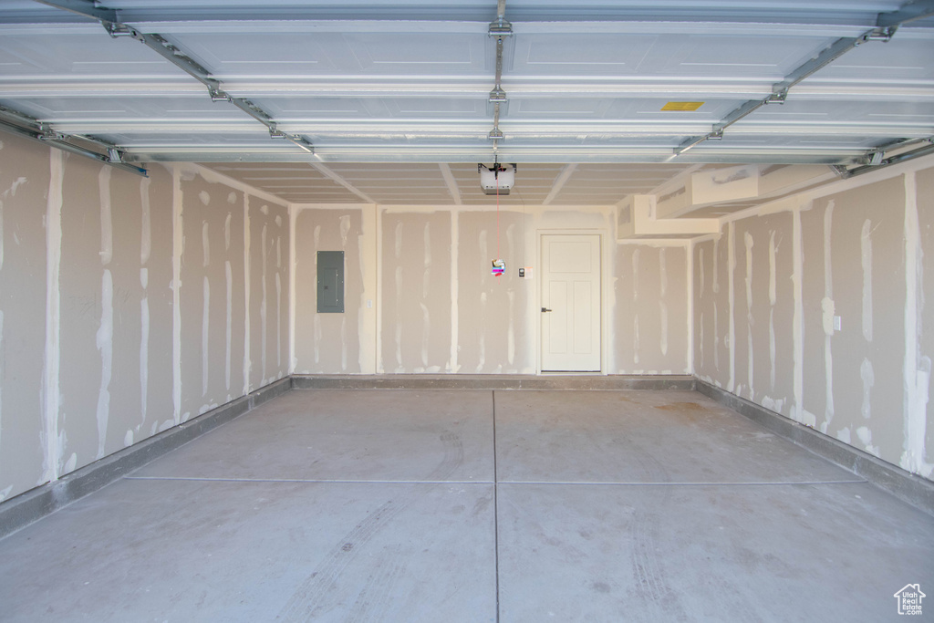 Garage featuring a garage door opener and electric panel