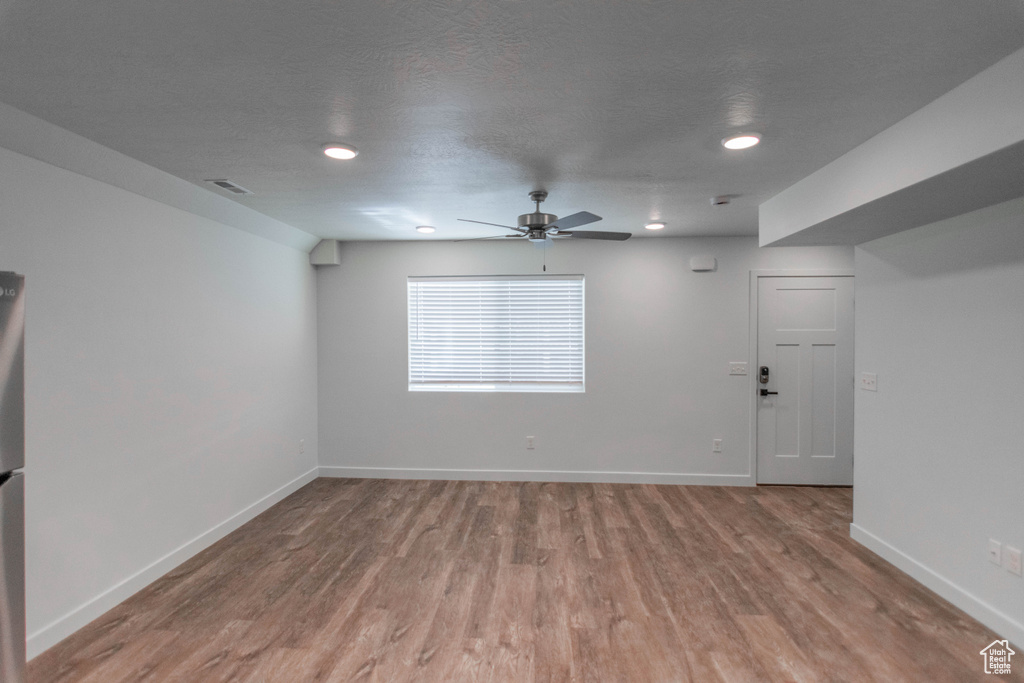 Empty room with a textured ceiling, ceiling fan, and hardwood / wood-style floors