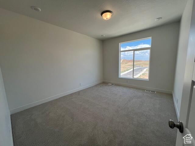 Spare room featuring carpet flooring