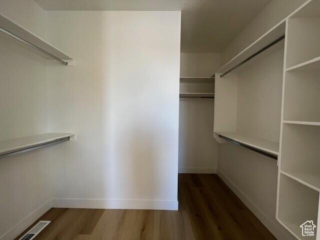 Spacious closet with hardwood / wood-style floors