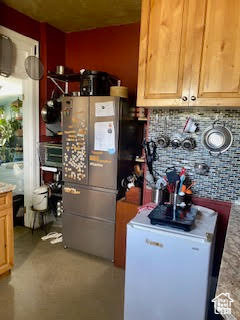 Interior space with backsplash and fridge