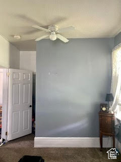 Interior space with dark colored carpet and ceiling fan