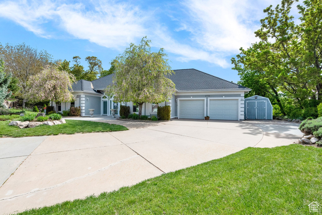 View of front of home featuring a front lawn and a garage