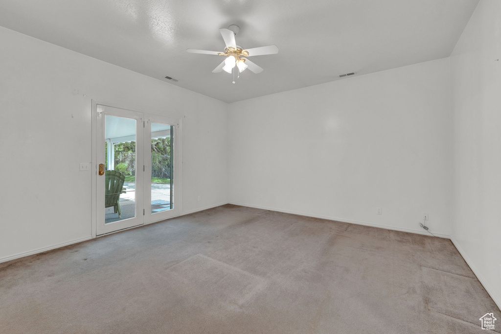 Unfurnished room featuring ceiling fan and carpet