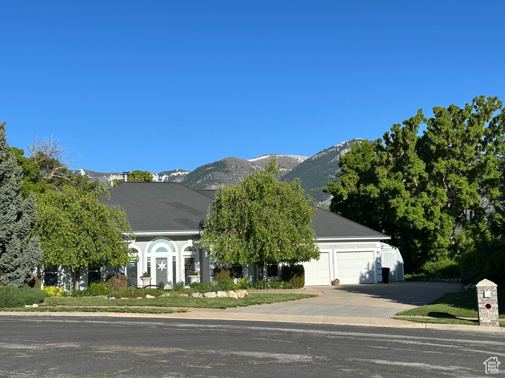 View of front of house with a mountain view and a garage