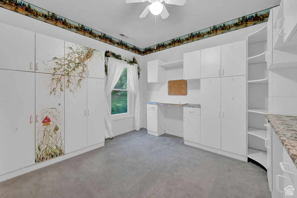 Interior space with light colored carpet and ceiling fan