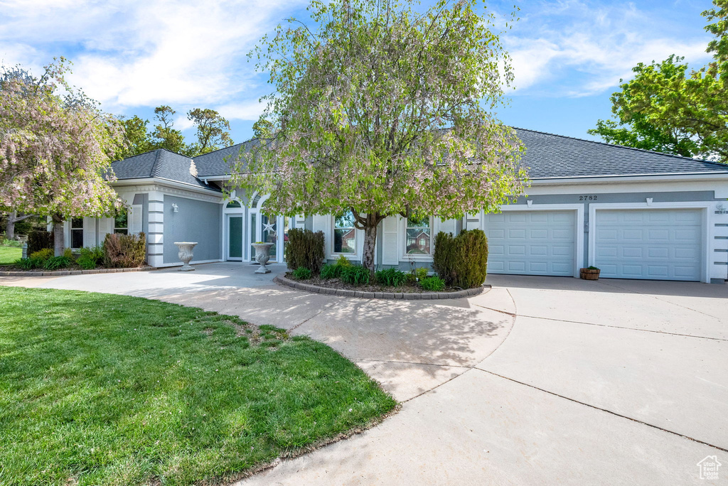 View of front of home featuring a garage and a front lawn