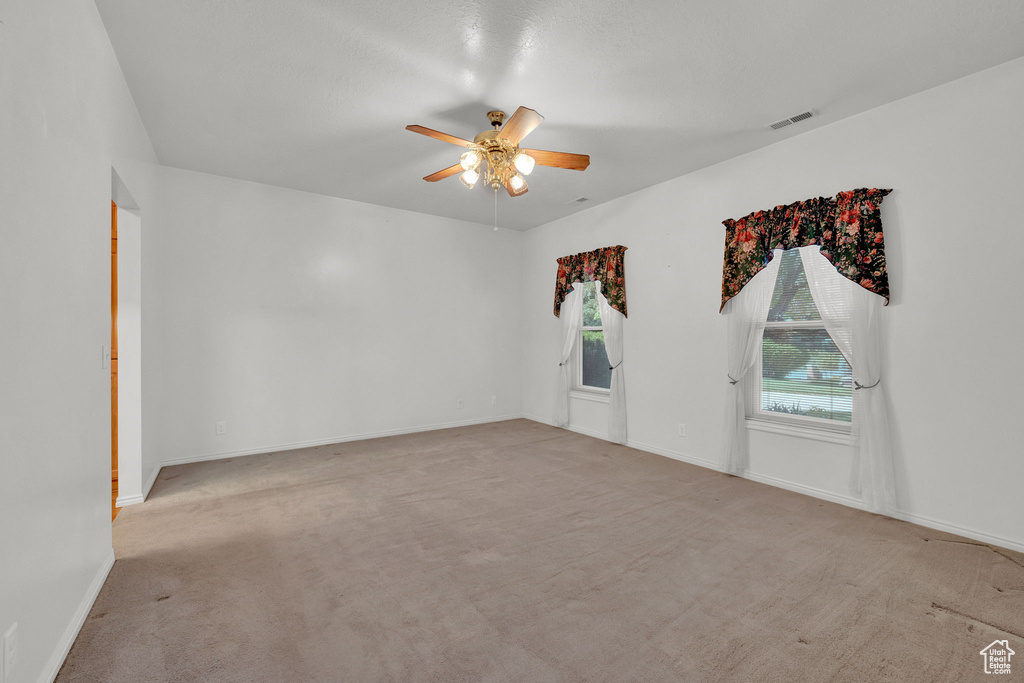 Carpeted spare room with ceiling fan