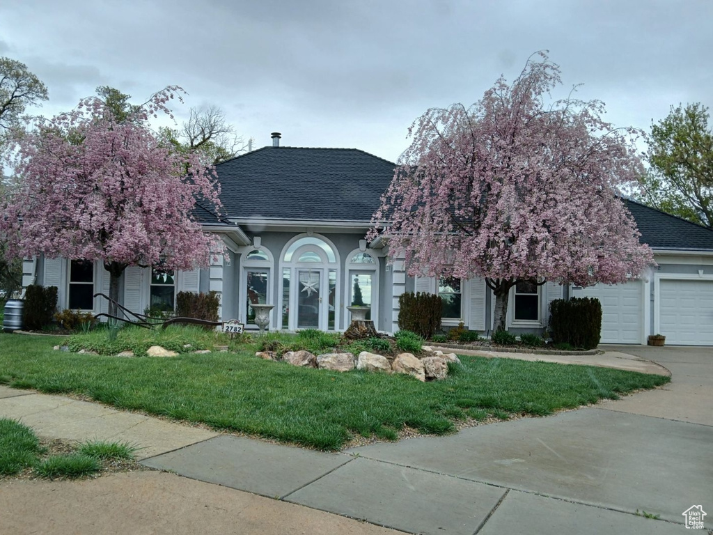 View of front facade with a garage and a front lawn