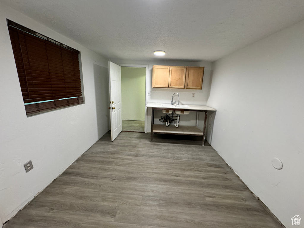 Interior space featuring hardwood / wood-style flooring, sink, light brown cabinetry, and a textured ceiling