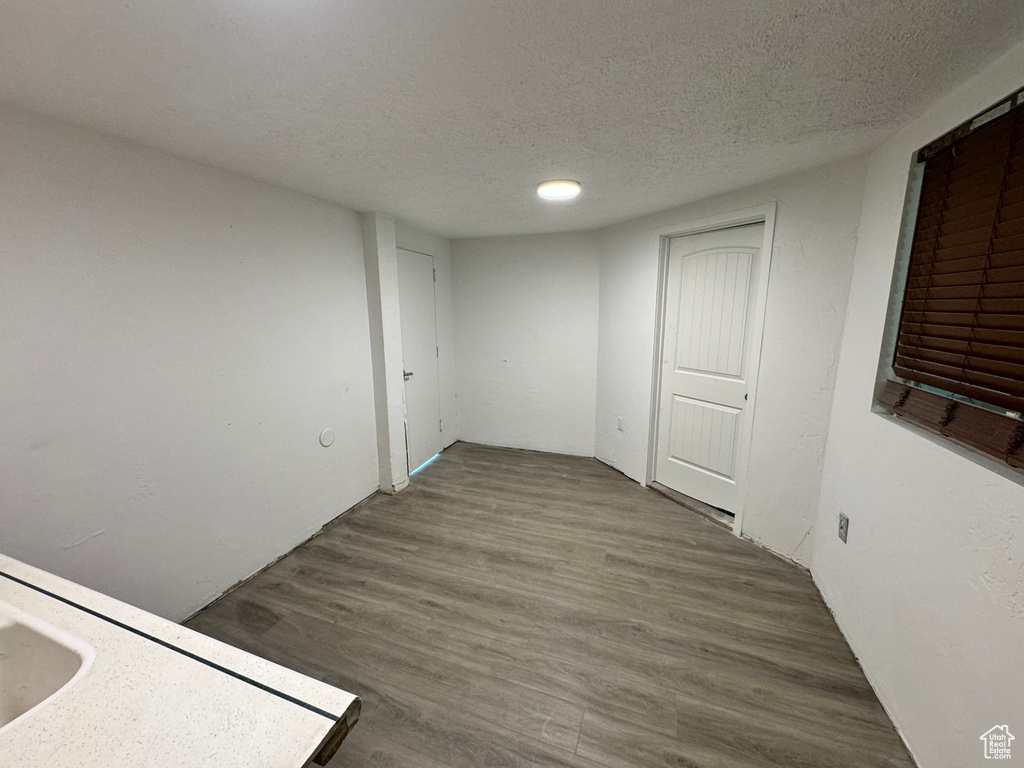 Empty room with a textured ceiling and hardwood / wood-style floors