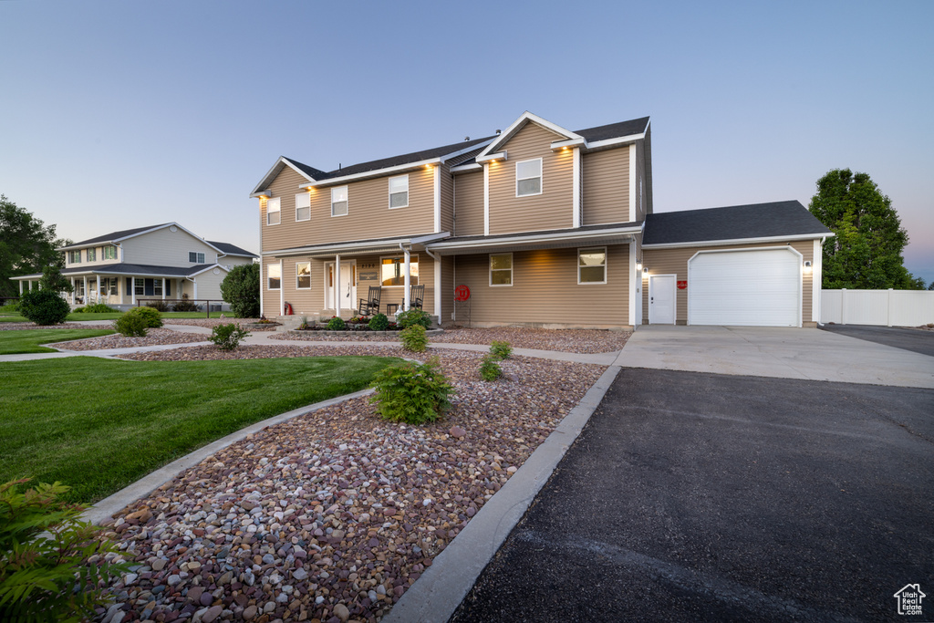 View of front facade with an attached garage, driveway, and a porch