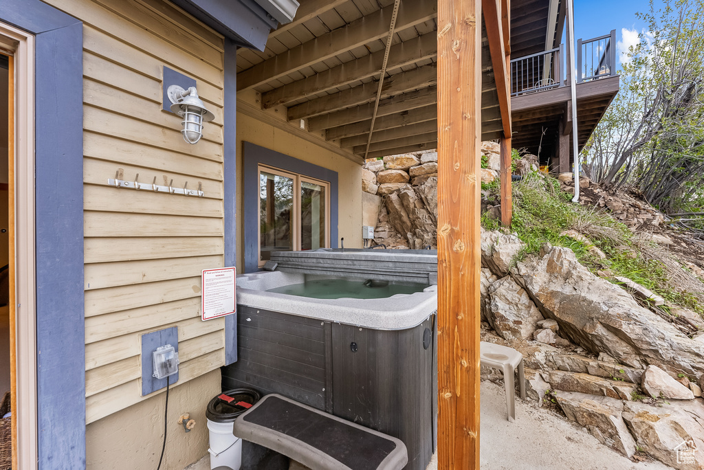 View of patio / terrace with a hot tub and a balcony