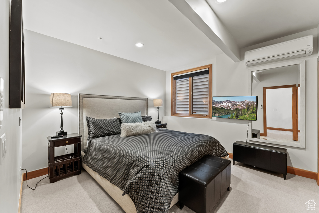 Bedroom with light colored carpet, beamed ceiling, and a wall unit AC