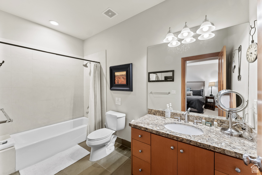 Full bathroom featuring tile floors, shower / bath combination with curtain, oversized vanity, and toilet